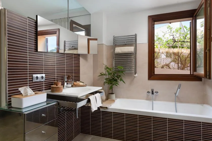 A bathroom with a sink, bathtub, and an open window.