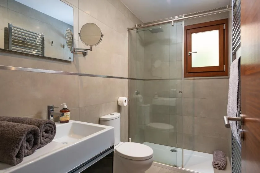 A tiled bathroom with a sink, toilet, and glass shower.