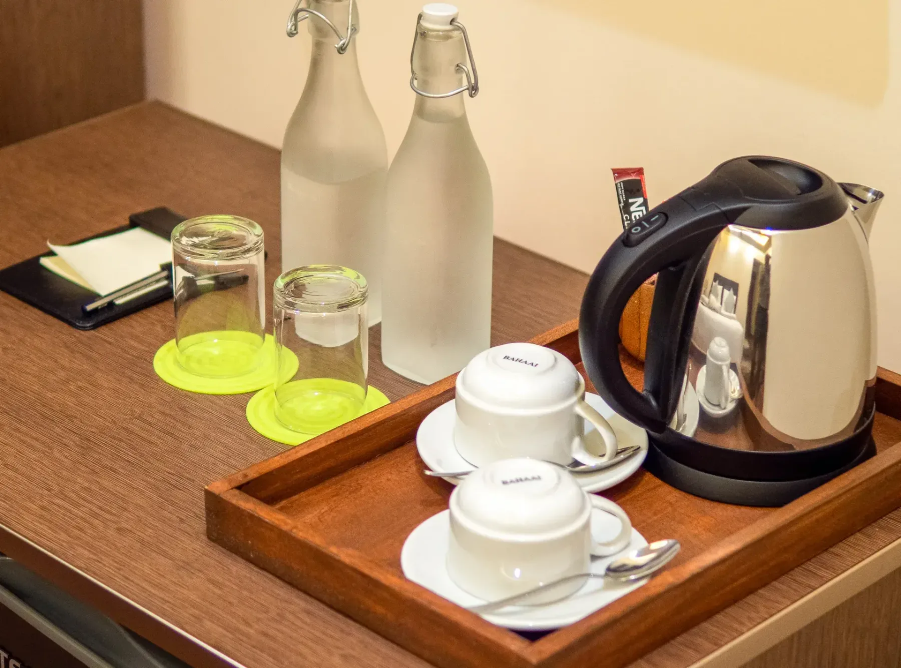 Un hervidor, tazas y botellas de agua en la habitación