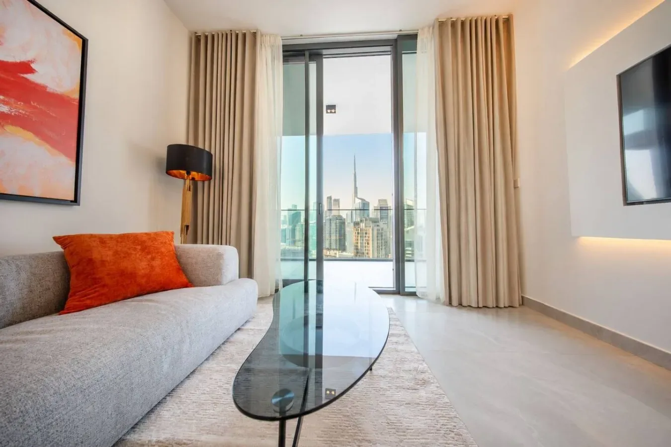 Una sala moderna con asientos, una mesa de centro de vidrio y vistas a la ciudad.