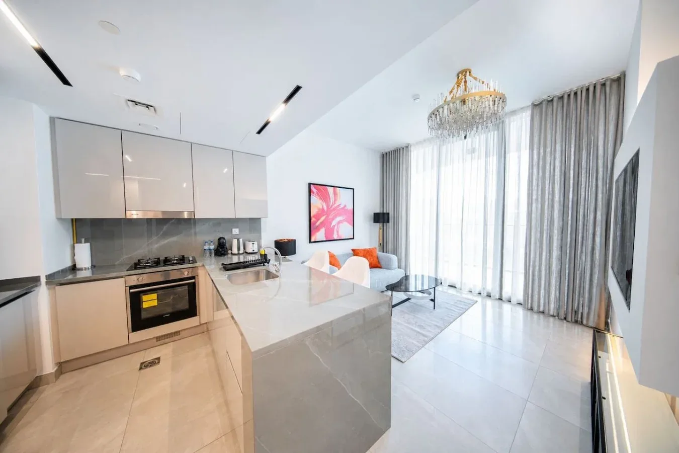 A bright open-plan kitchen and living area with a central island and large windows.