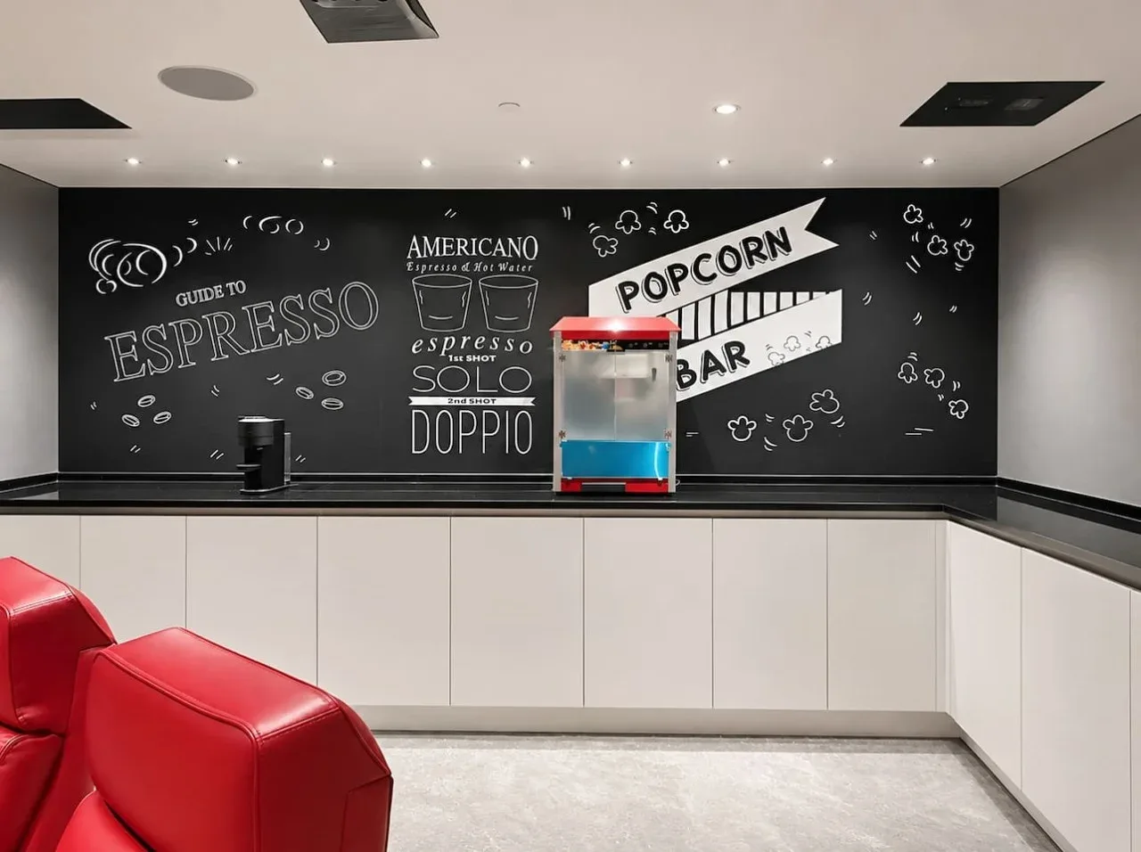 A refreshment counter with a popcorn machine and coffee-themed wall art.