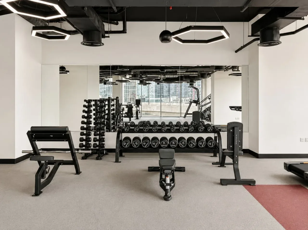 A gym with weight racks, dumbbells, and exercise benches.