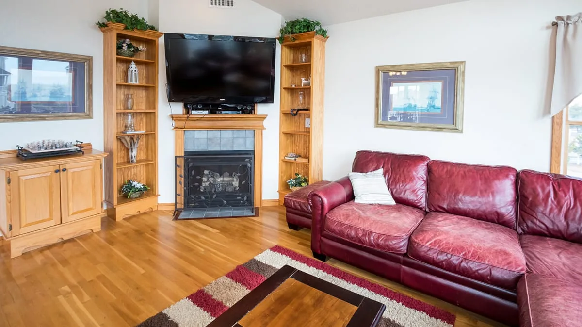 Living room with red seating, a fireplace, and a television.