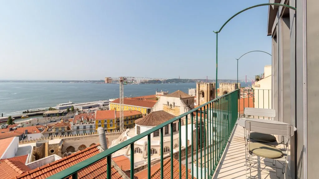 Una terraza da a tejados y a un río amplio.