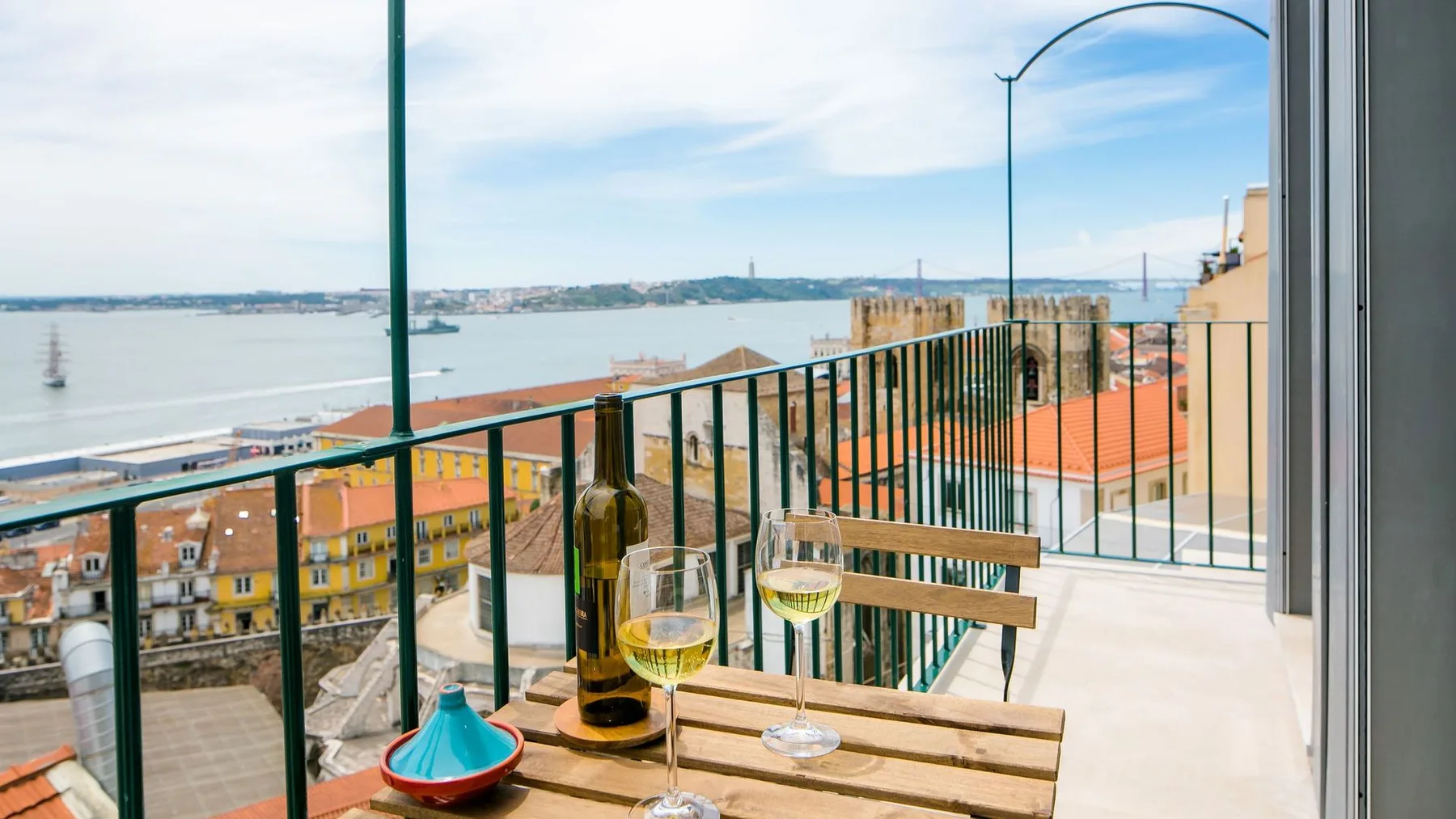 Una terraza en la azotea ofrece vistas al paseo marítimo, con una mesa pequeña y asientos.