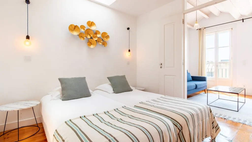 Un dormitorio luminoso con una cama bien hecha y decoración en la pared.
