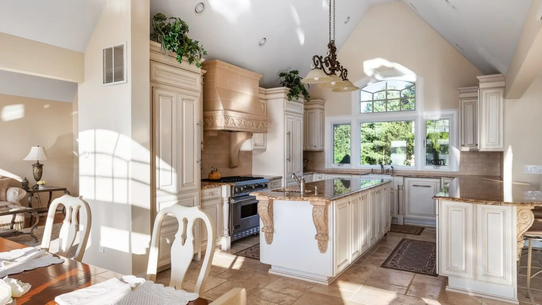 Una cocina luminosa con una isla central, gabinetes y ventanas grandes.