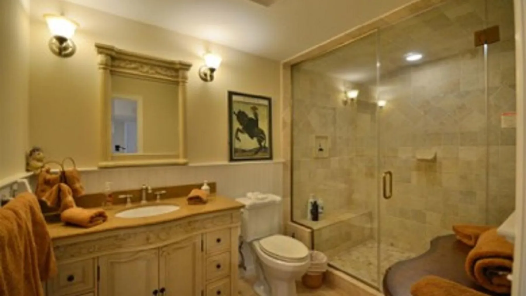 Un baño con lavabo, inodoro y ducha con mampara de vidrio.
