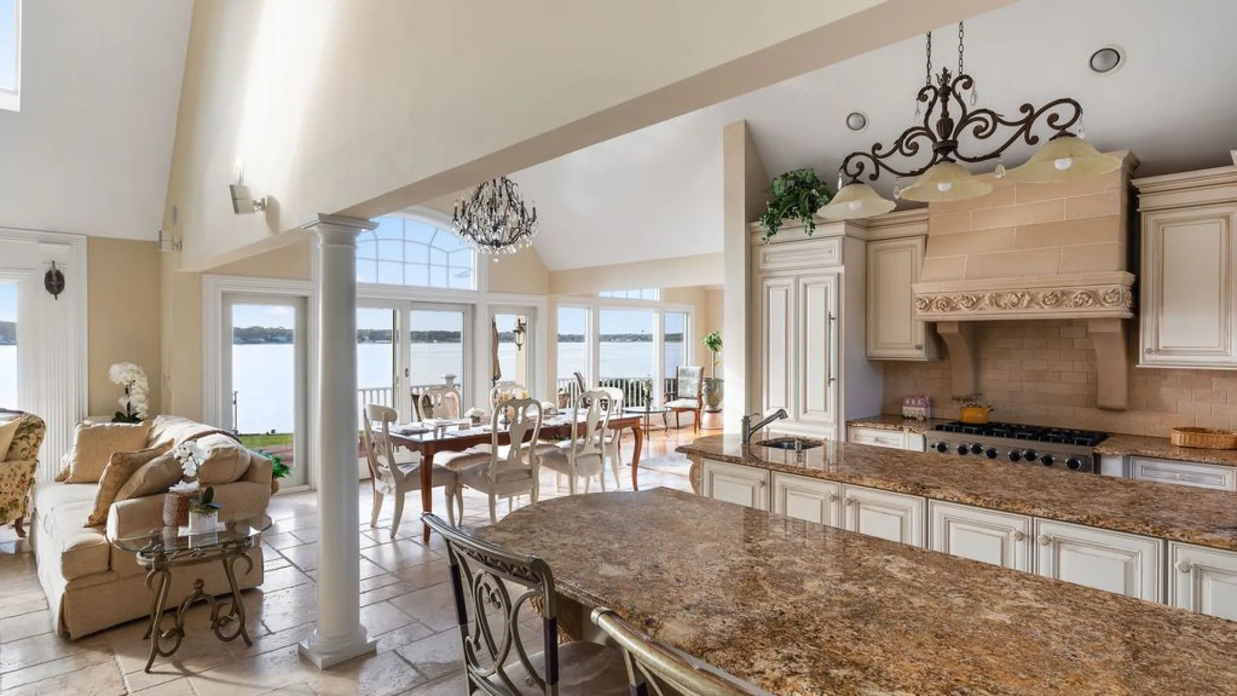 Una amplia cocina y comedor con una gran isla y ventanas con vistas al agua.