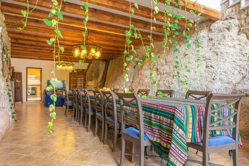 A dining area with a long table covered in colorful striped fabric.