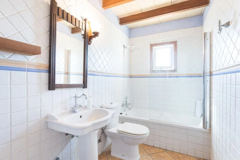 A bright bathroom with a bathtub, sink, and toilet.