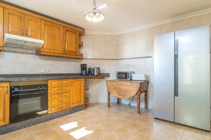 A kitchen with wooden cabinets, a countertop, and a refrigerator.