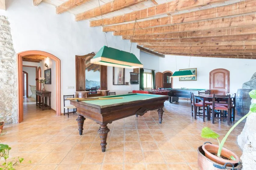 A game room with a billiards table and a dining area.