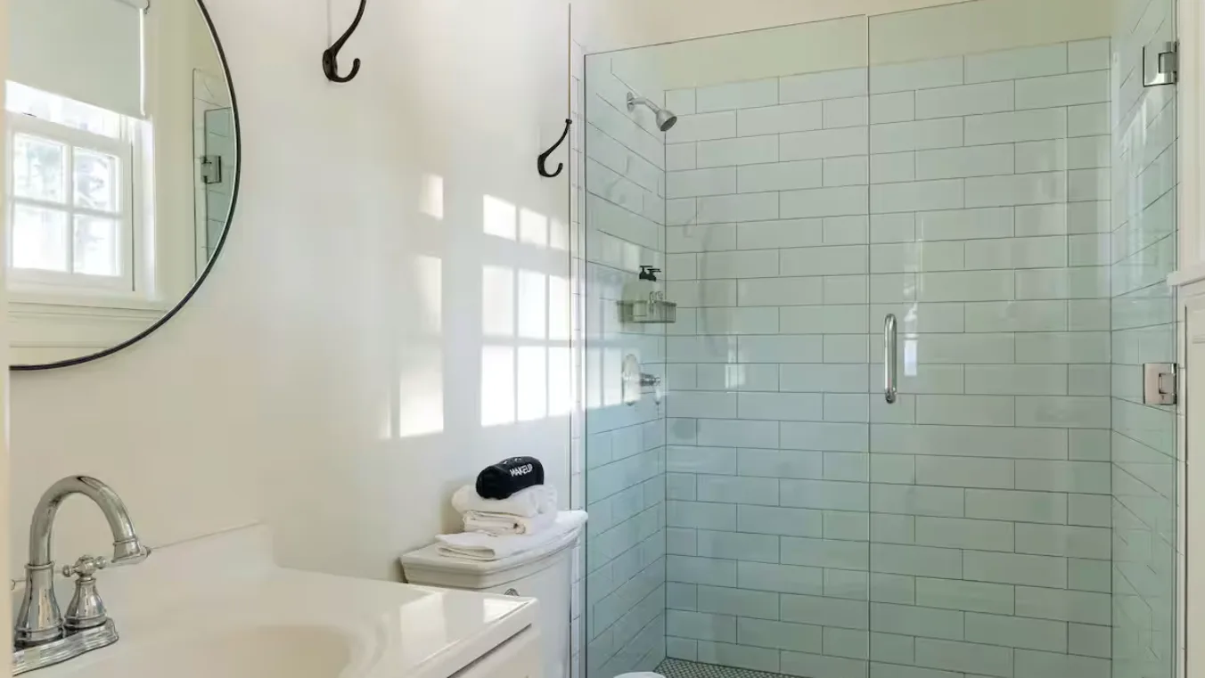A bathroom with a glass shower and a white vanity.