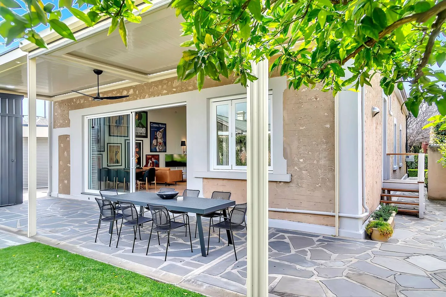 The alfresco patio is designed for breezy summer meals, with a ceiling fan overhead and a kitchen servery window for effortless entertaining.