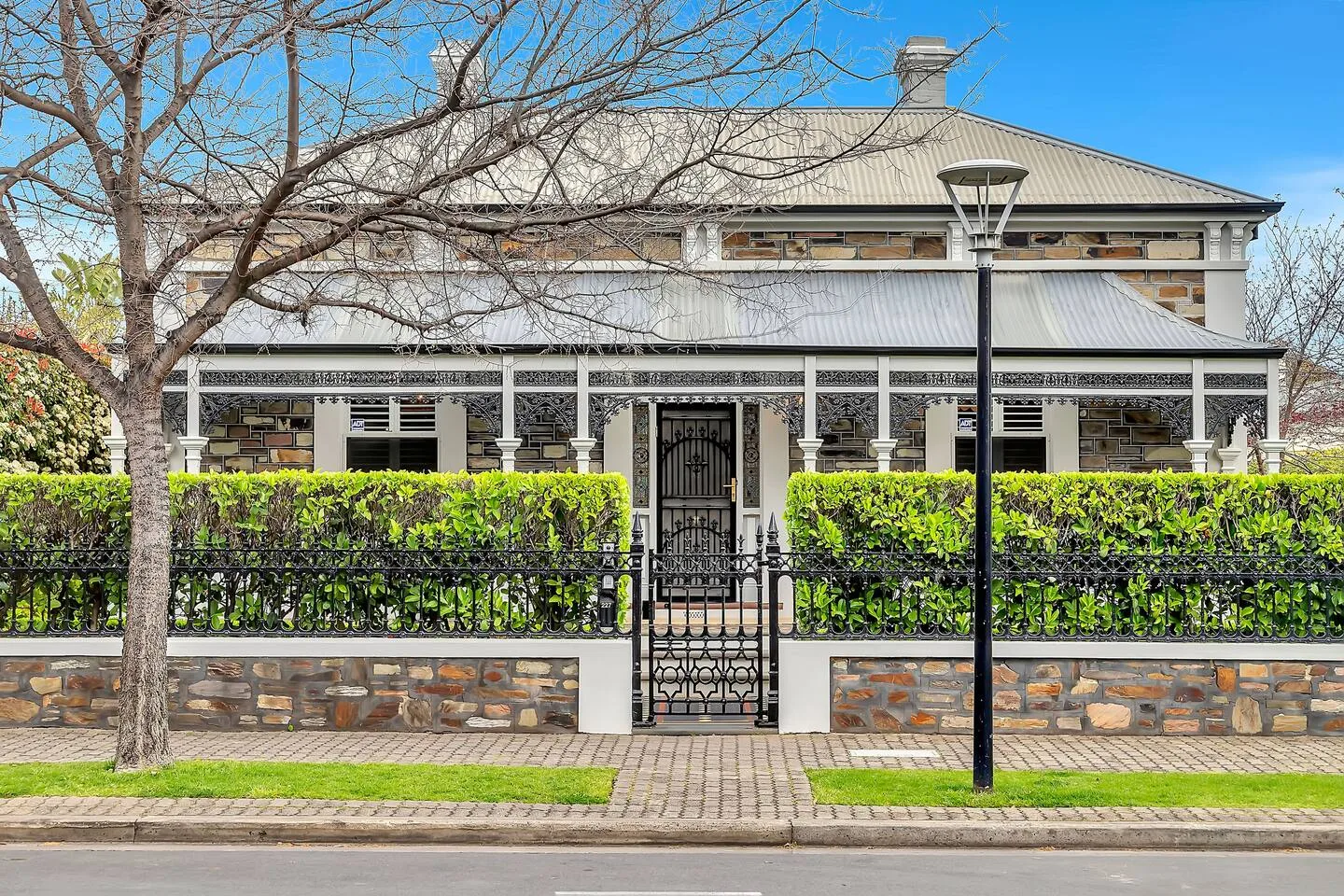 Set behind manicured hedges and a decorative gate, the home's timeless façade and heritage details offer a warm, elegant welcome.