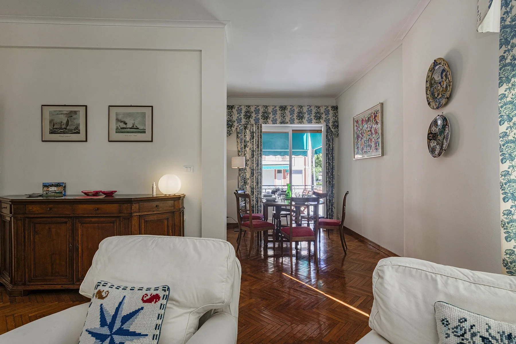 Una sala de estar se abre a un comedor con mesa y sillas.
