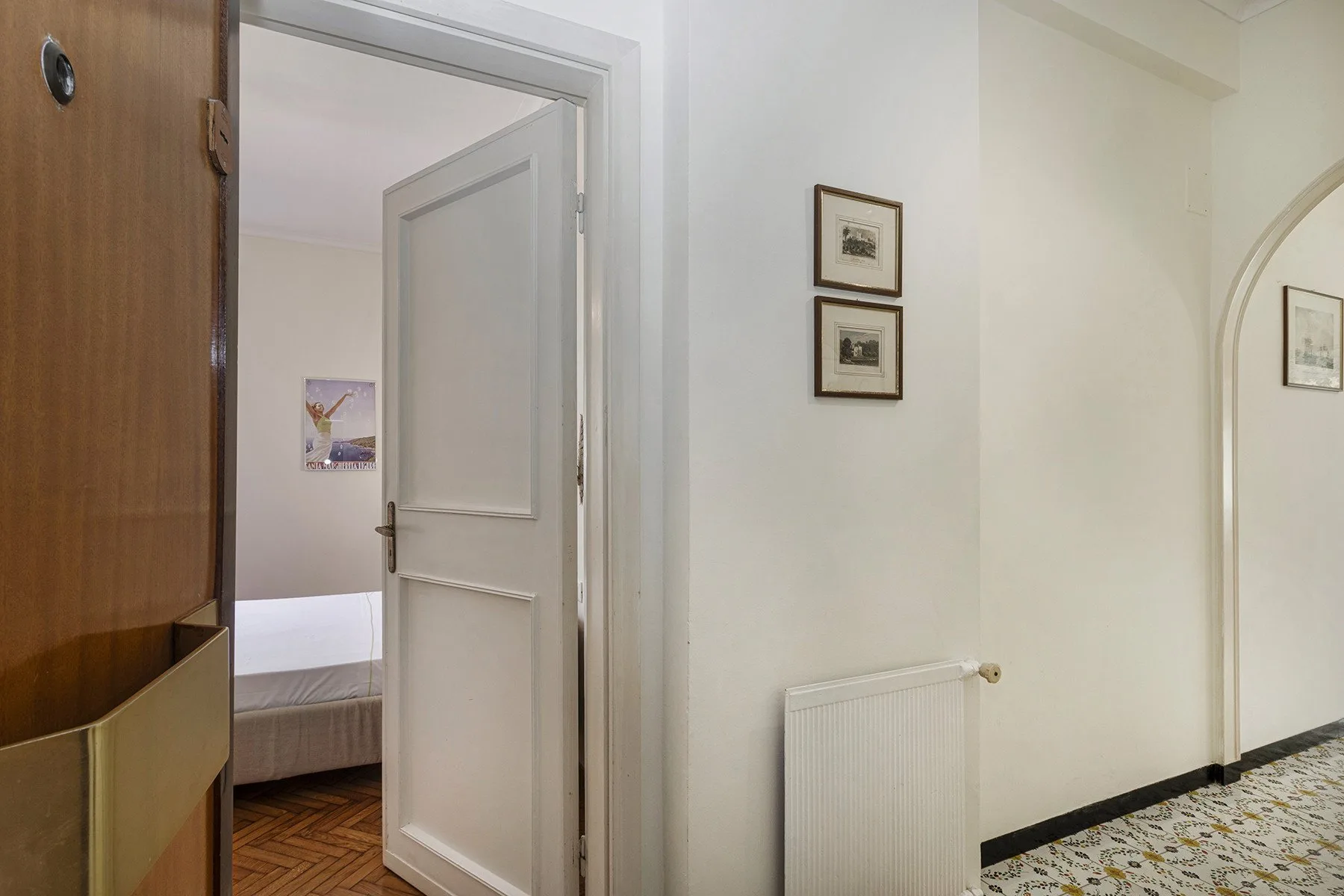Un pasillo interior con una puerta abierta que da a un dormitorio.