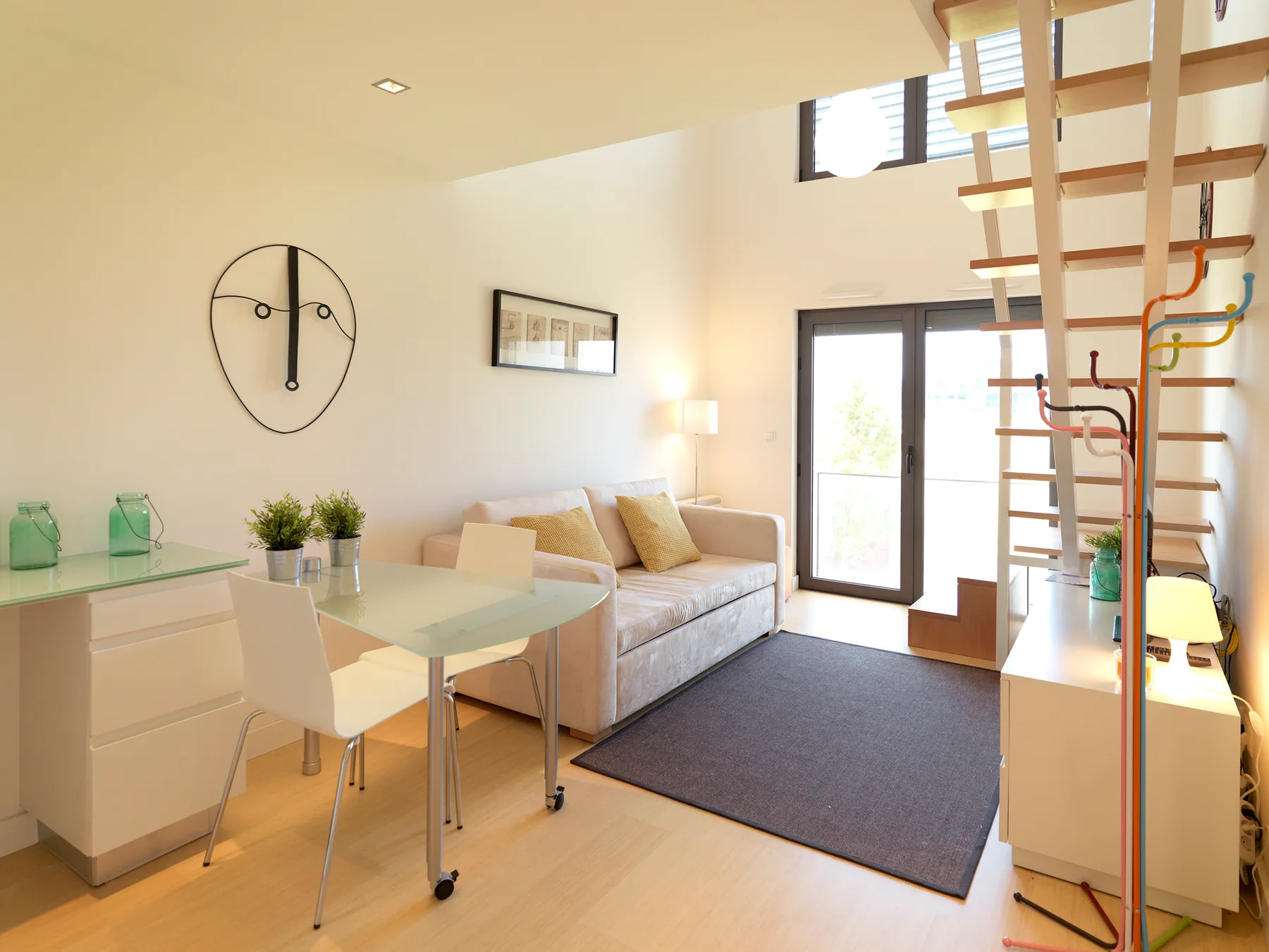 A bright living area with a dining table, seating, and a large rug.