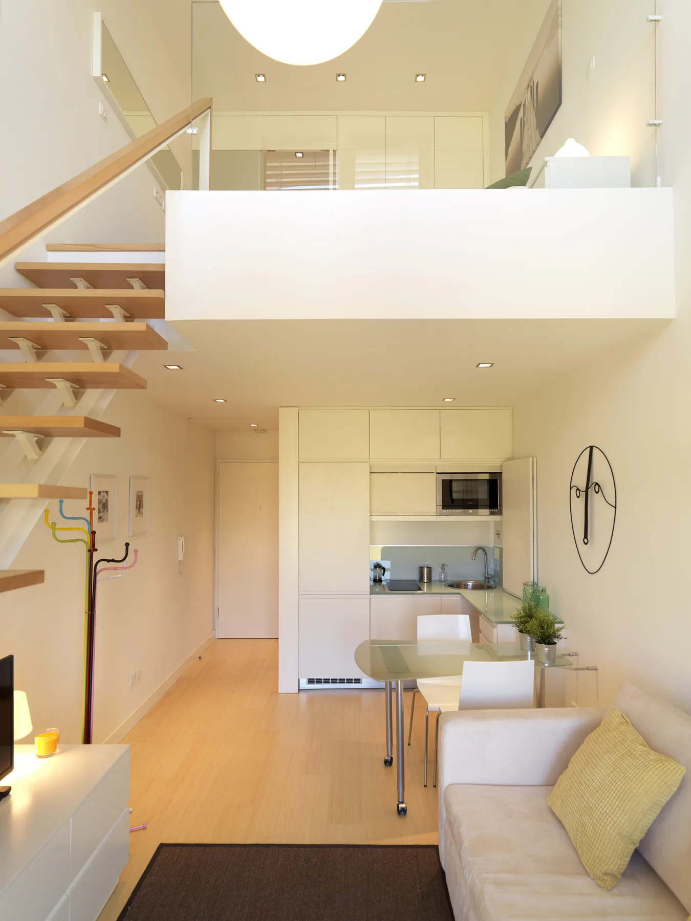 A bright open-plan living area with a dining table and staircase.