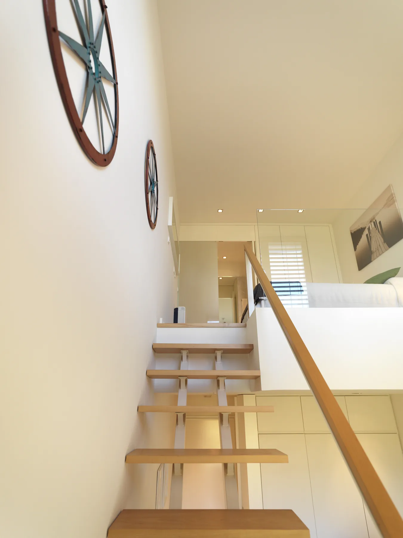 A bright interior staircase leads up to a loft area.