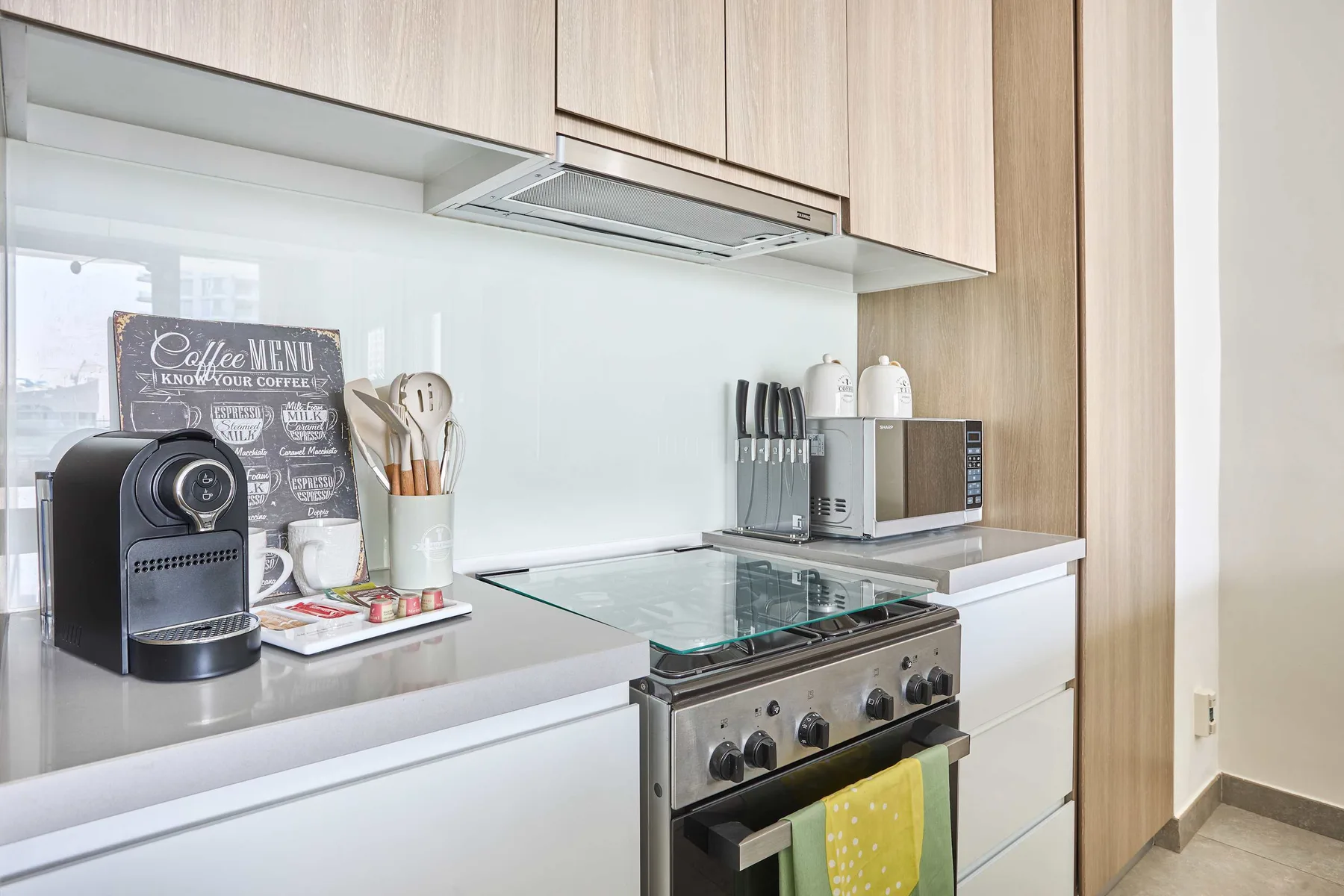 A bright kitchen with a countertop espresso machine beside the stove.