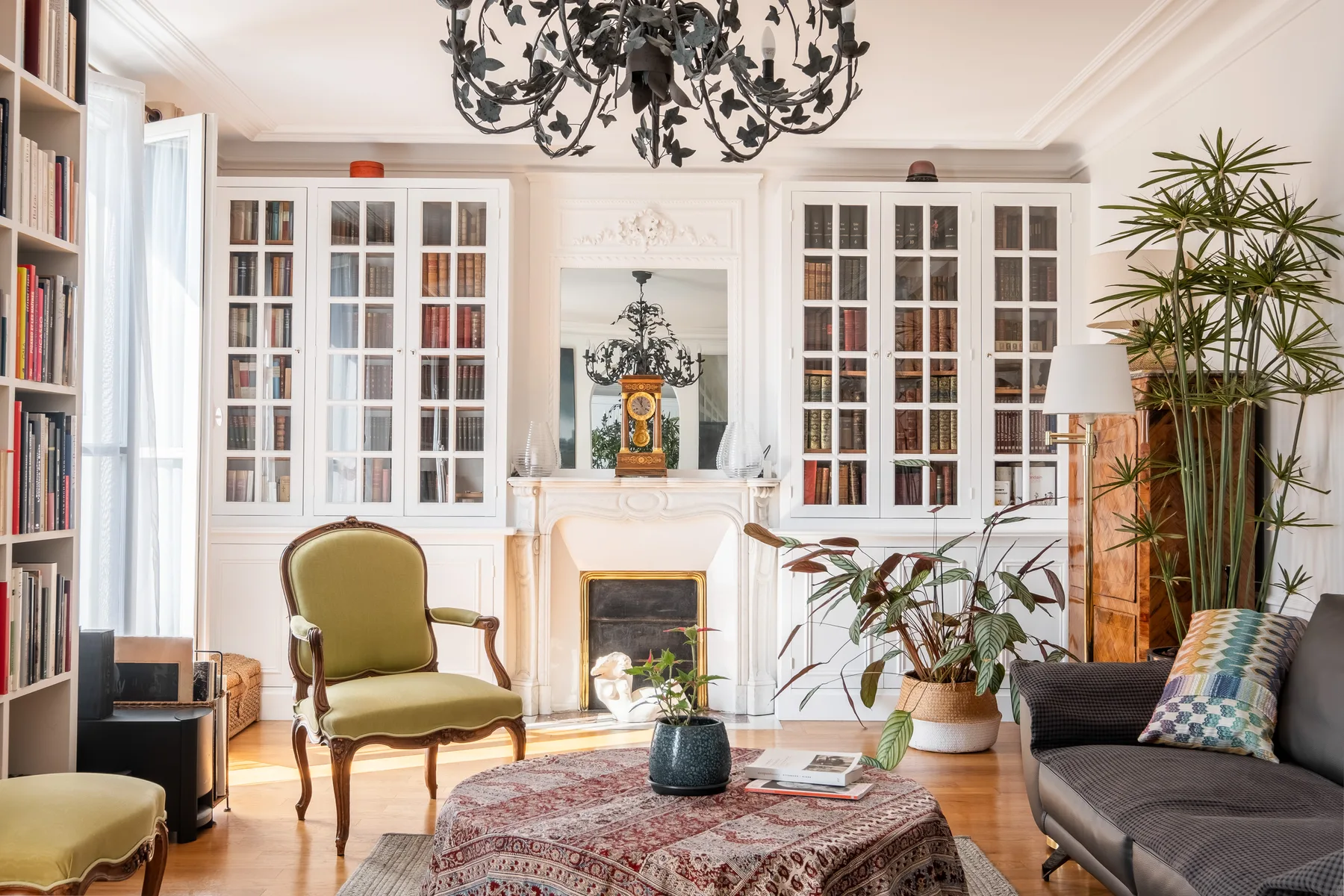 A bright living room with a fireplace, bookcases, and seating.