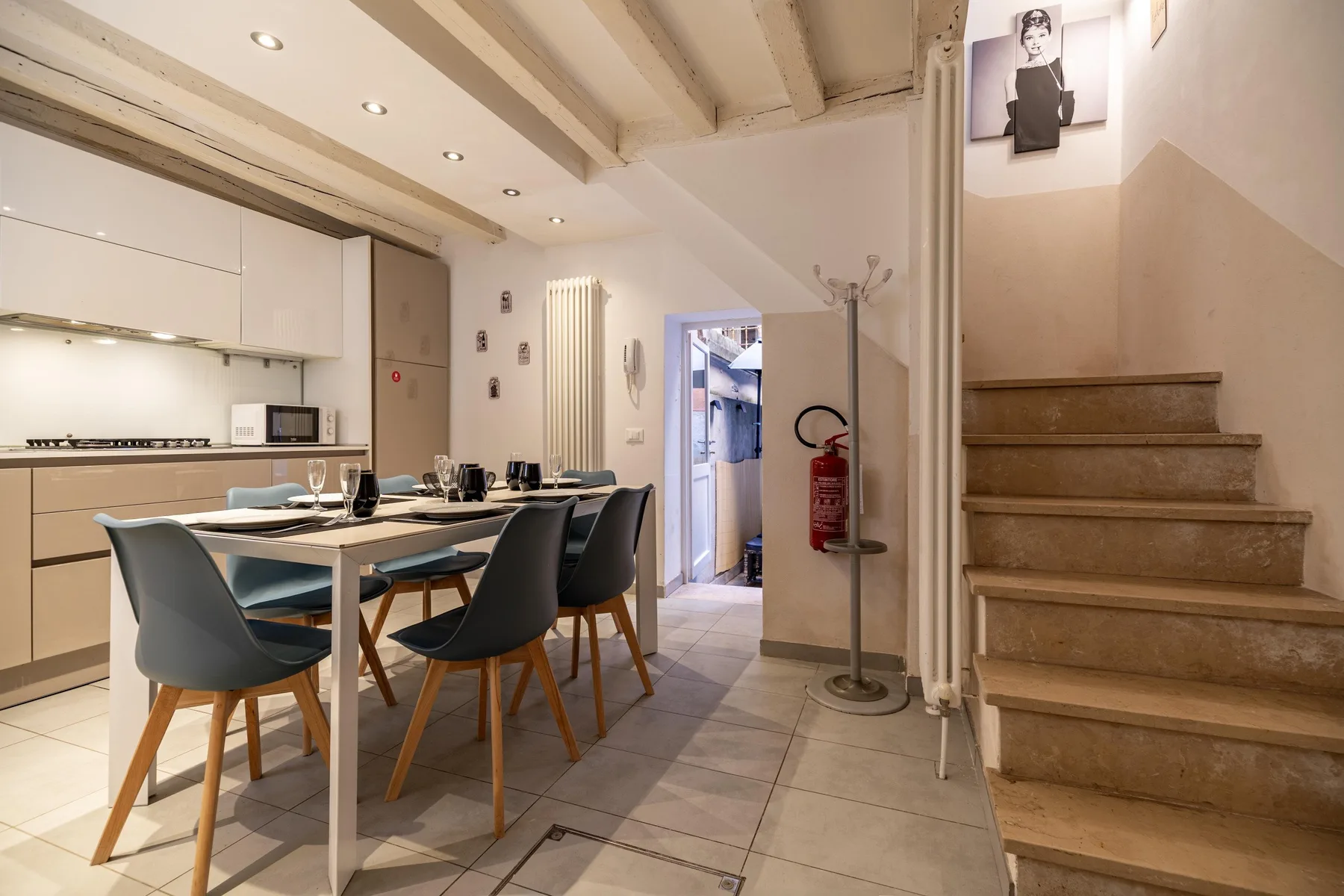 Un comedor con una mesa larga y una escalera contigua.