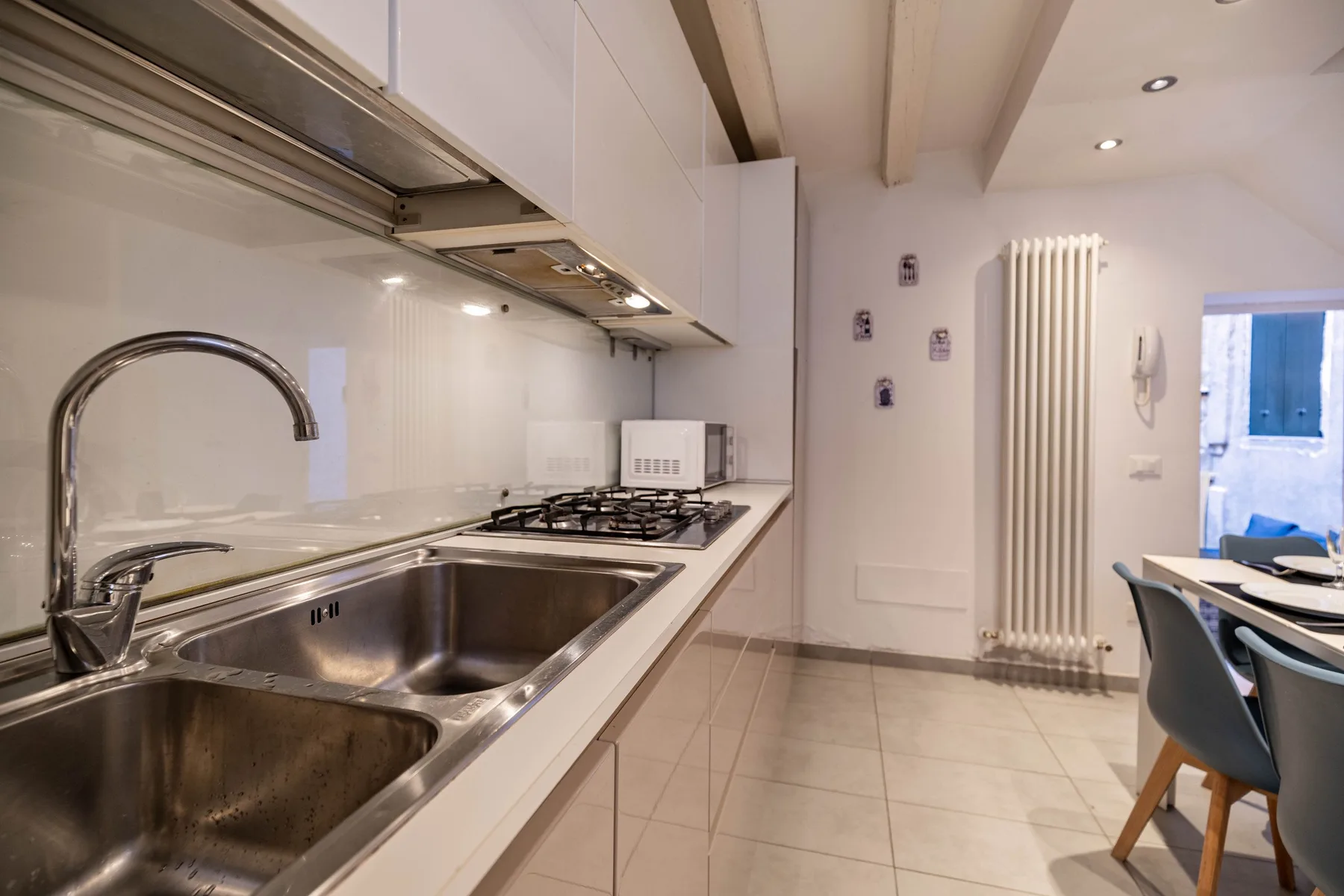 Una cocina luminosa con fregadero y estufa junto a un comedor.