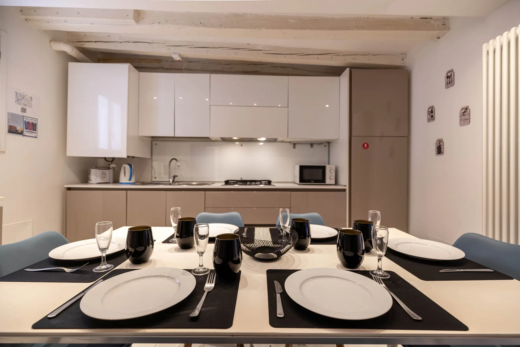 Una mesa preparada para comer está frente a una cocina compacta.