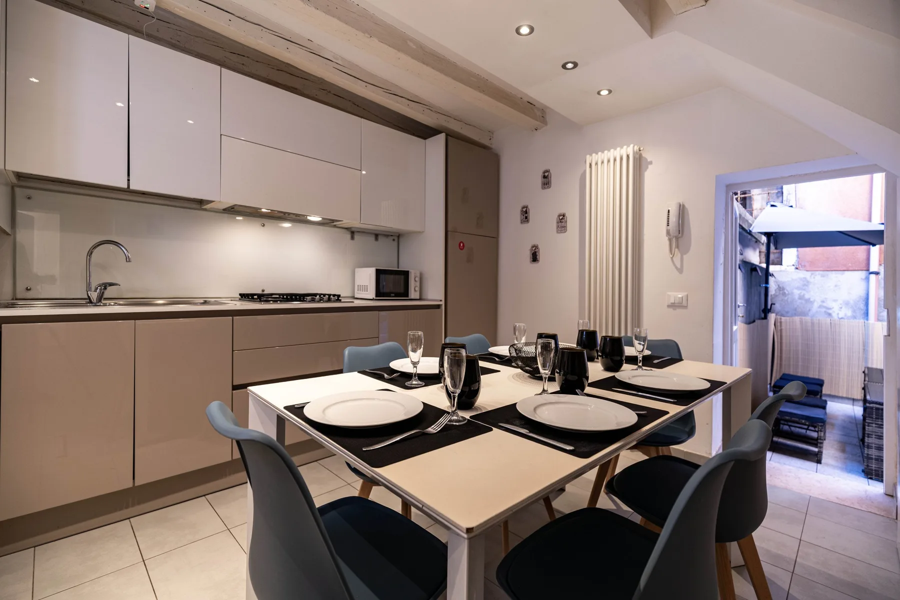 Un comedor con la mesa puesta está junto a una cocina compacta.