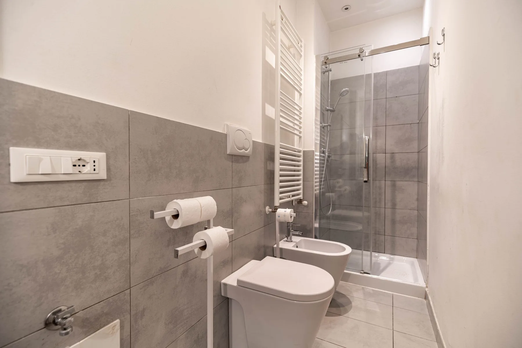 Un baño con azulejos, un inodoro y una ducha de vidrio.