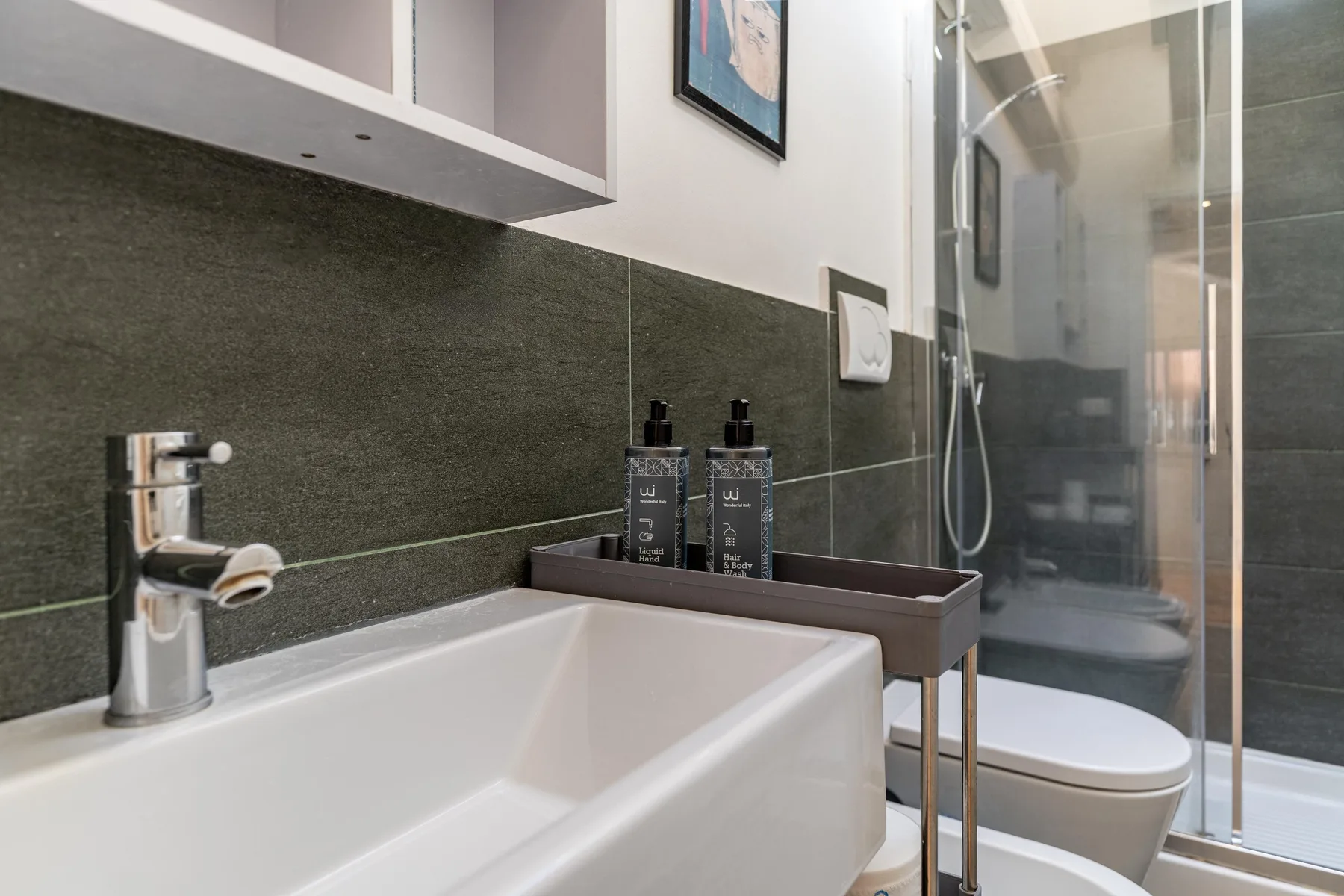 Un baño moderno con lavabo, inodoro y ducha con mampara de vidrio.
