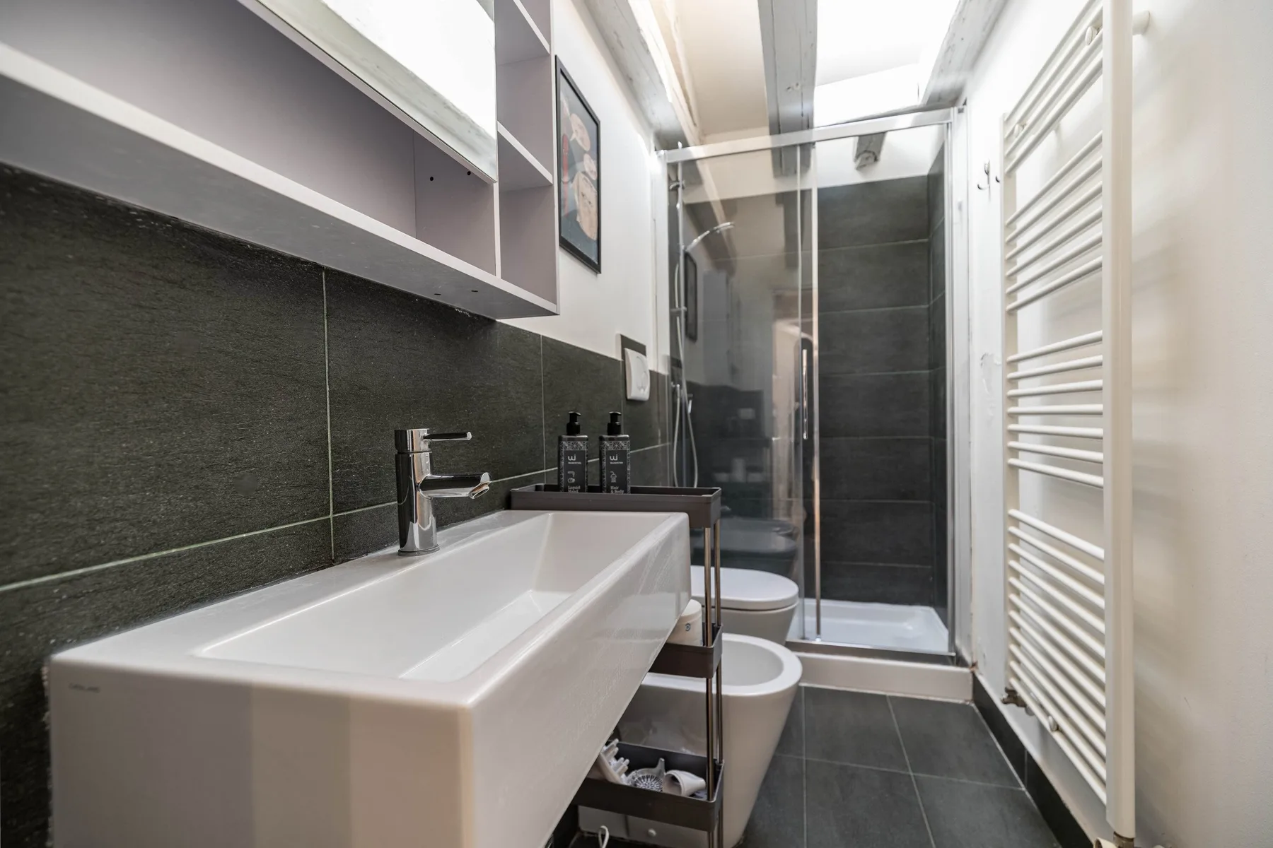 Un baño moderno con lavabo, inodoro y ducha de cristal.