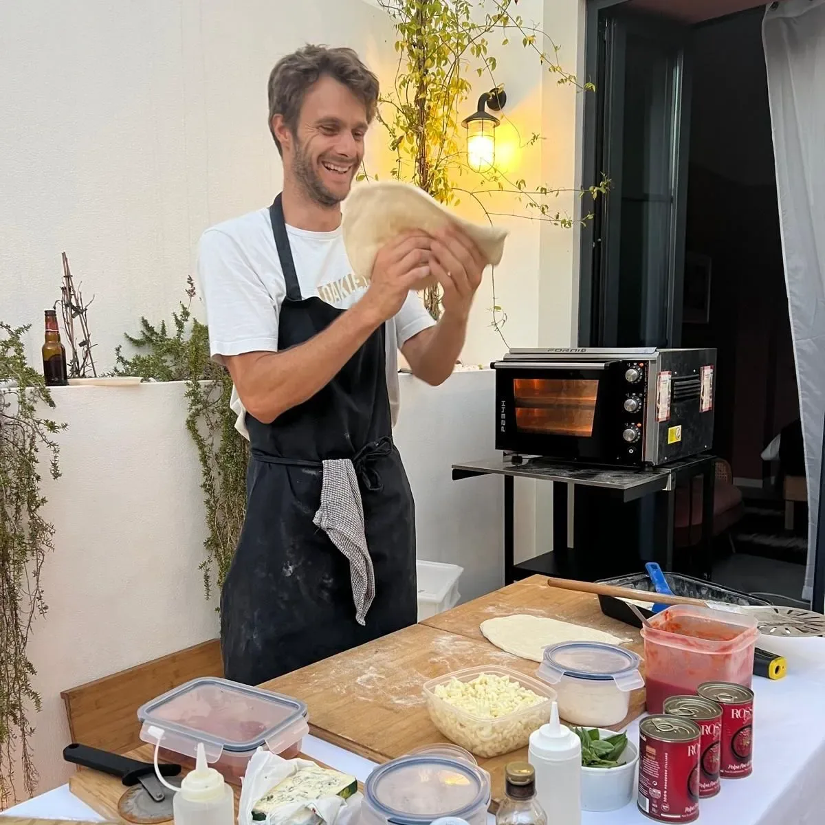 A cook preparing pizza dough.