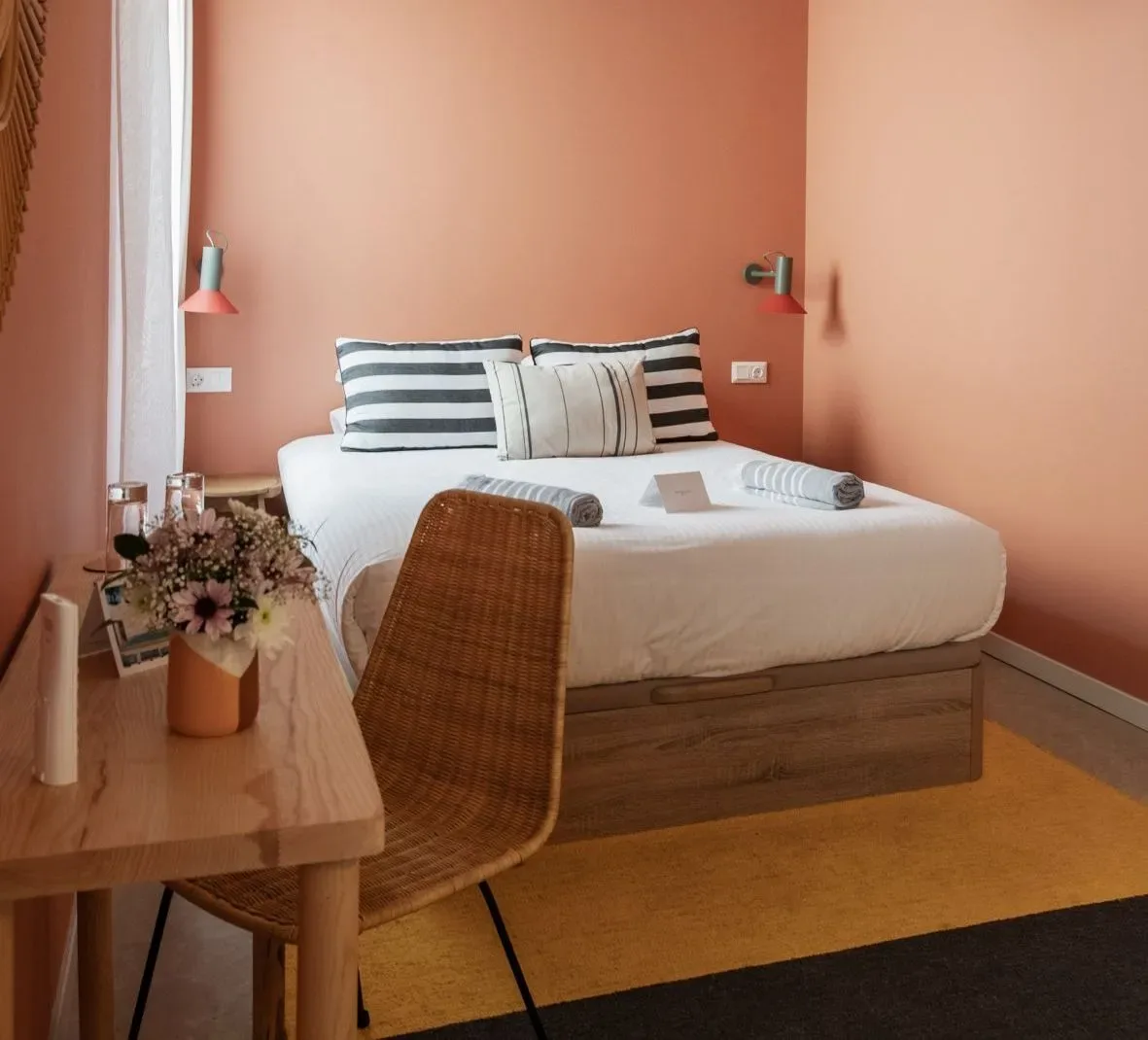 A guest room with a bed, desk, and chair.