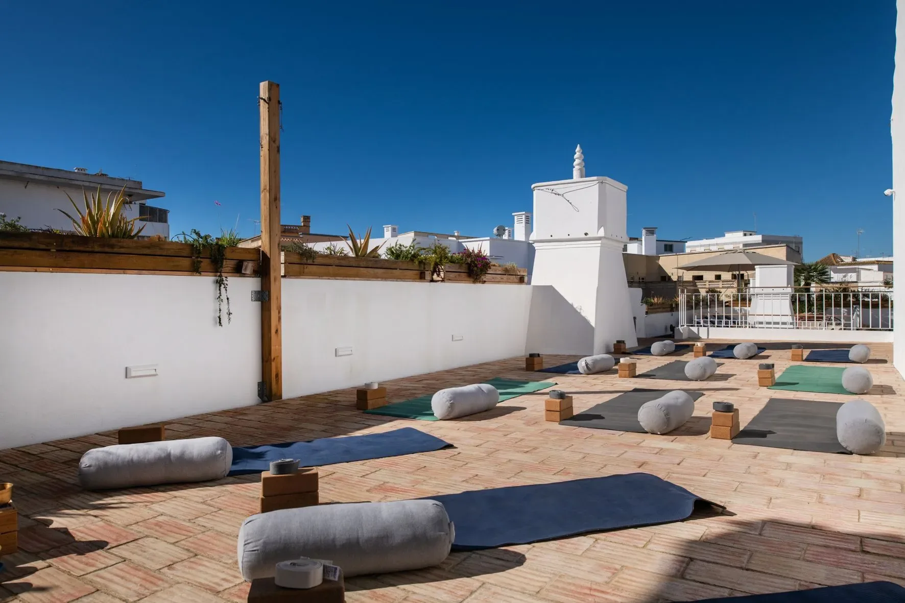 Yoga mats and cushions arranged on the terrace.