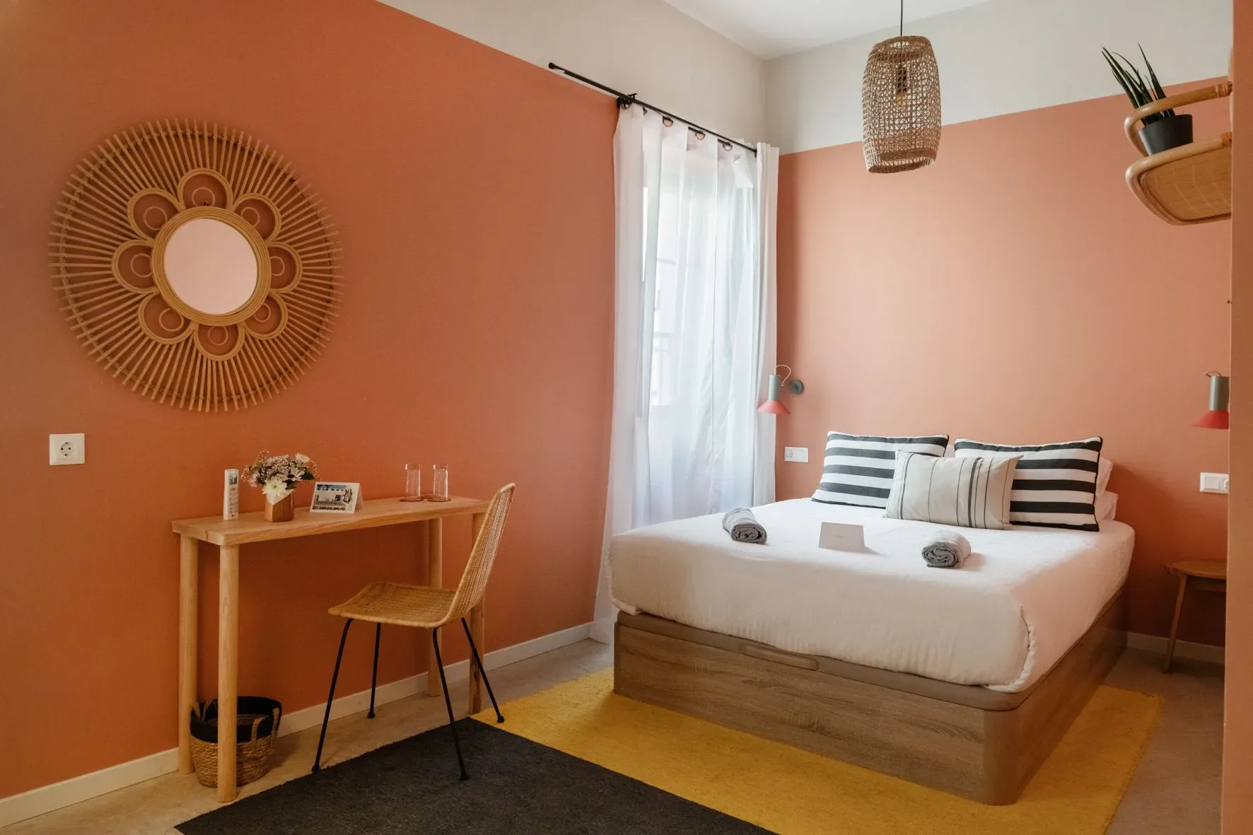 A guest room with a bed, desk, and chair.