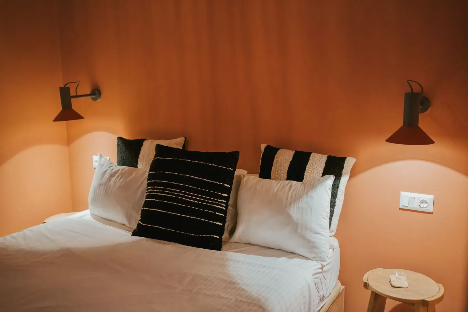 A guest room with a bed and warm-toned walls.