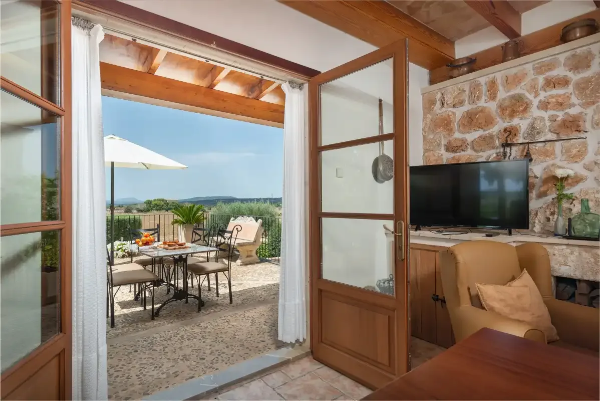 Una sala de estar se abre a una terraza con asientos al aire libre y vistas al campo.