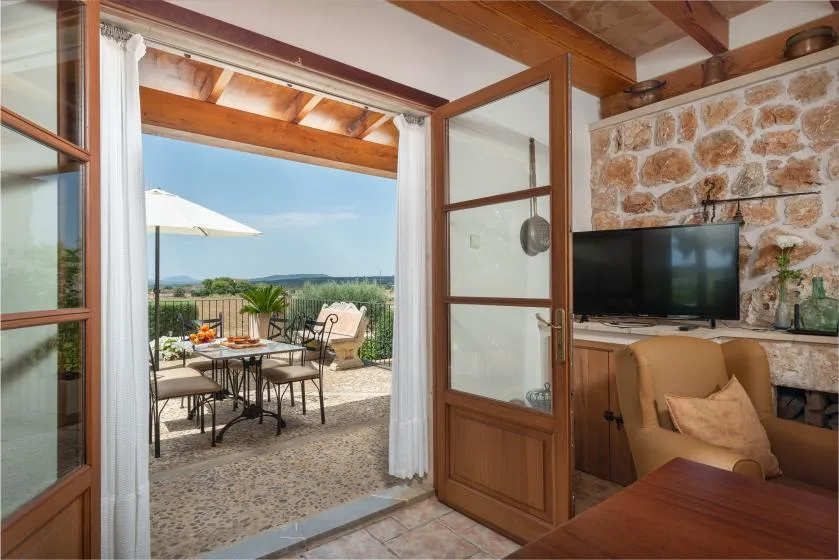 Una sala de estar se abre a una terraza con asientos al aire libre y vistas al campo.