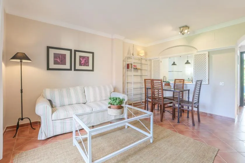 A living and dining area with seating, a glass coffee table, and a dining table.