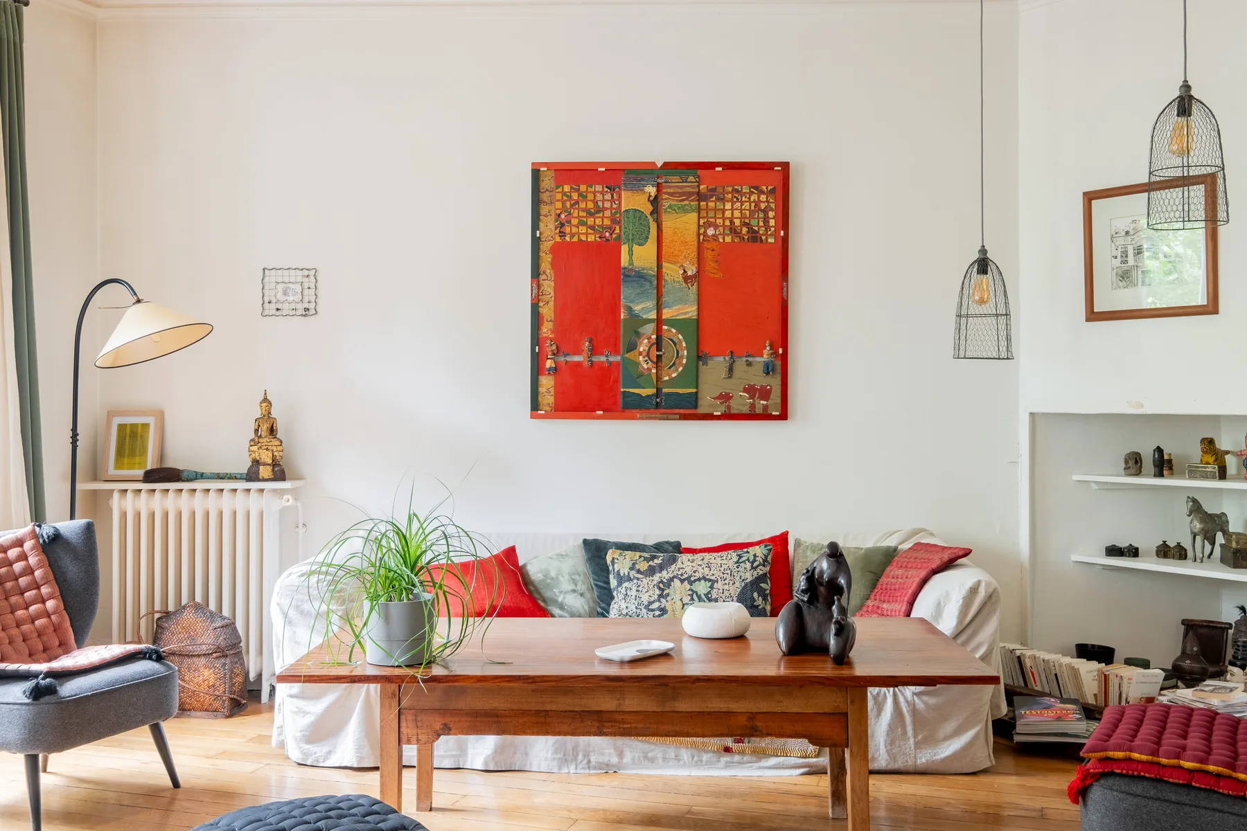 A bright living room with colorful artwork above a low wooden table.