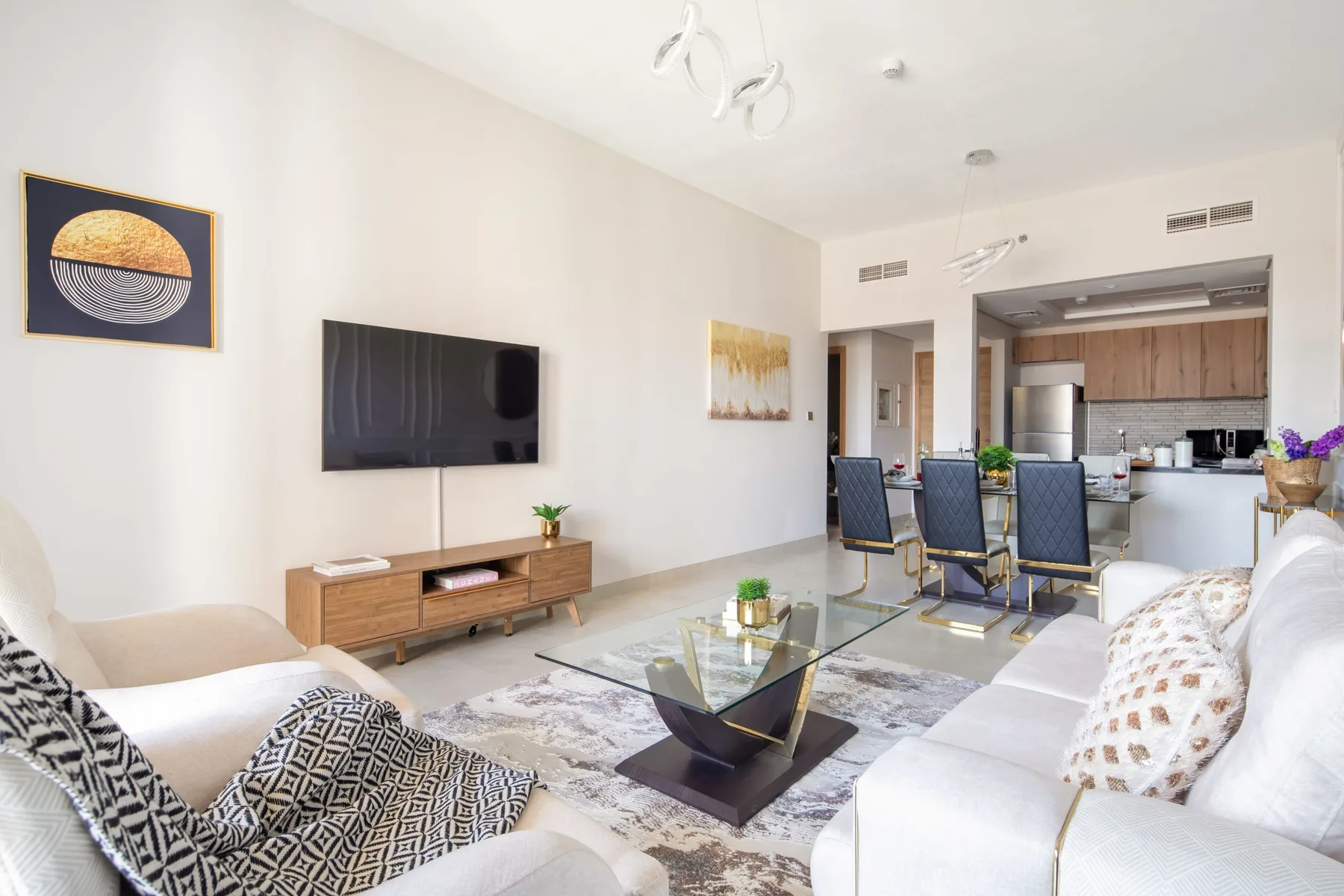 Una sala luminosa con asientos, un televisor y un comedor.