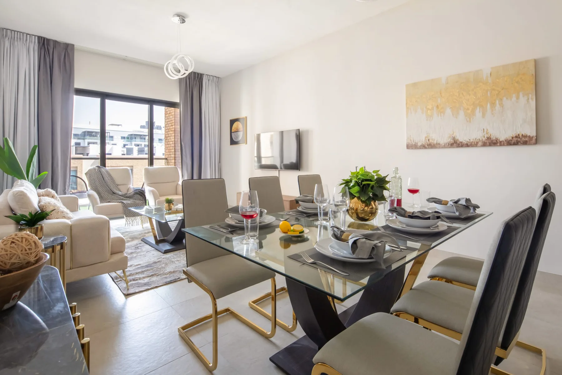 Una luminosa sala de estar y comedor con una mesa de vidrio y asientos junto a las ventanas.