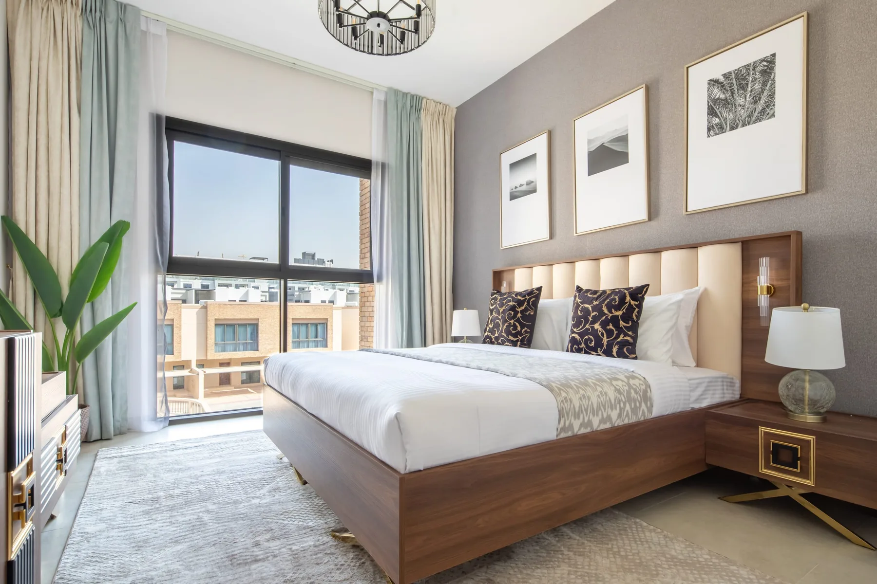 Un dormitorio con una cama de madera, cojines estampados y una ventana grande.