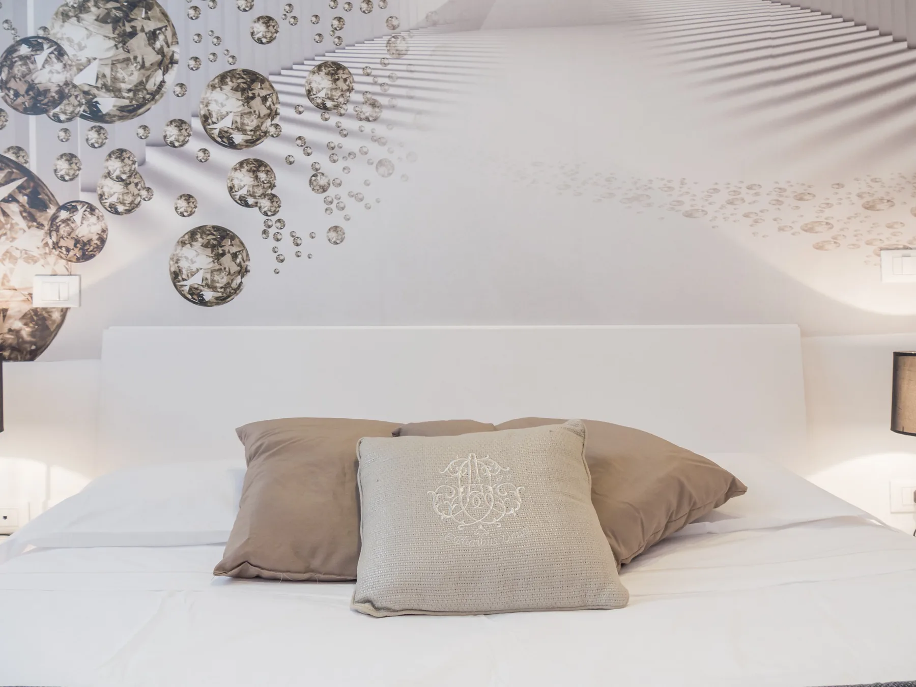 Un dormitorio con una cama bien tendida y arte decorativo sobre el cabecero.