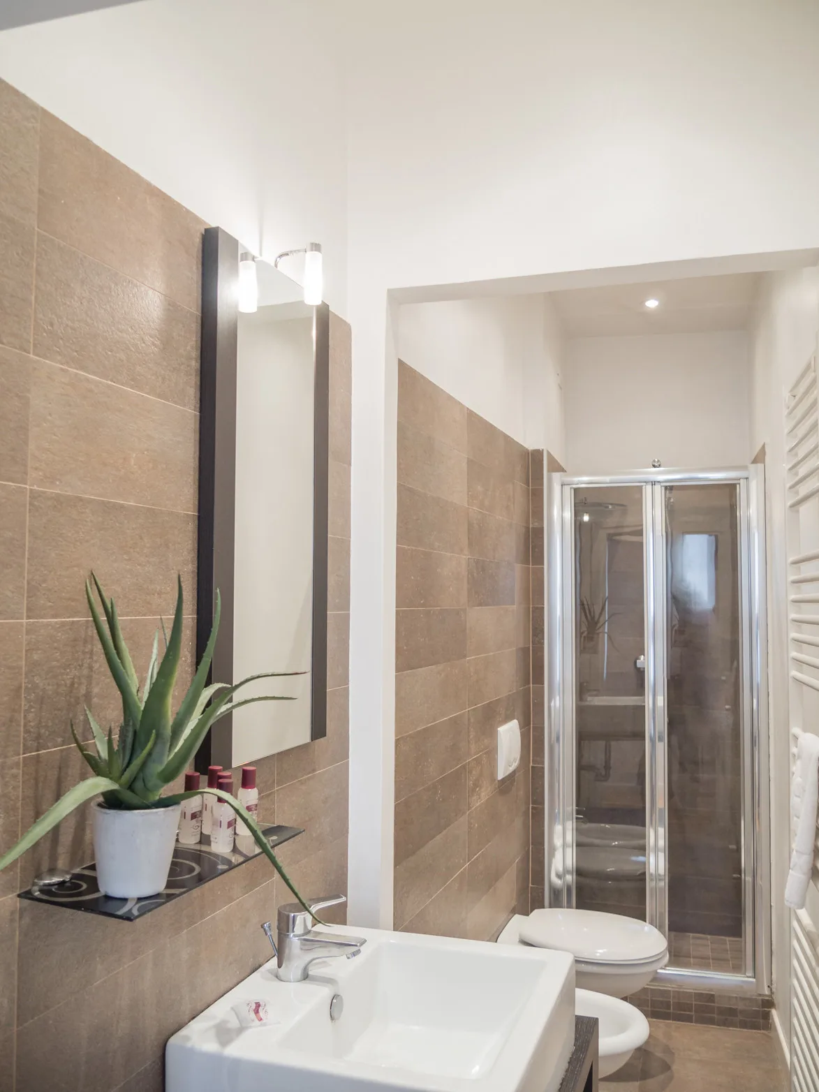 Un baño con lavabo, espejo y ducha de vidrio.