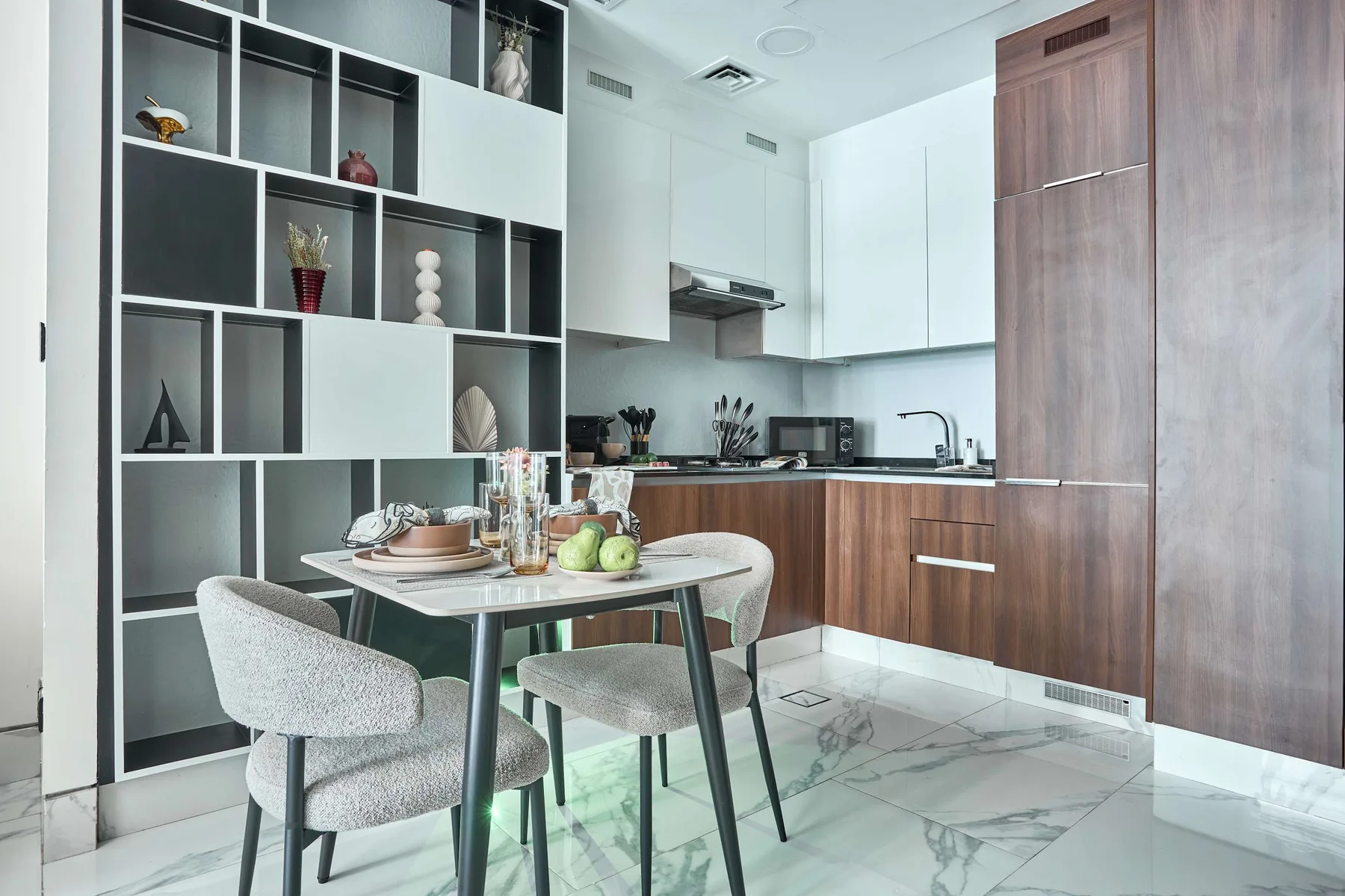 Una cocina moderna con mesa de comedor y estanterías abiertas.
